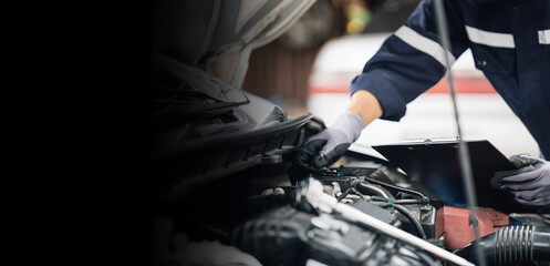 Mechanic works on the engine of the car in the garage. Repair service. Concept of car inspection service and car repair service.