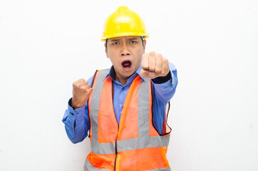 stressed over work concept illustrated by asian male construction worker in blue shirt, orange vest and yellow safety helmet with furious, mad, sad, angry expression. overworked concept