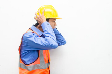 side view of stressed over work concept illustrated by asian male construction worker in blue shirt, orange vest and yellow safety helmet with furious, mad, sad, angry expression. overworked concept