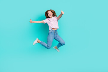 Fototapeta na wymiar Full length photo of charming pretty girl dressed pink t-shirt jumping high showing thumbs up isolated teal color background