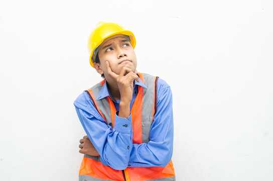 thoughtful asian male construction worker in pensive mood doing thinking and wondering gesture.