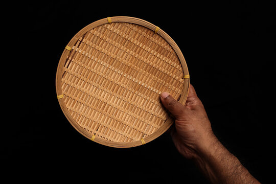 Asian dark skin top view two hand finger holding empty wooden bamboo woven plate dish tray on black background