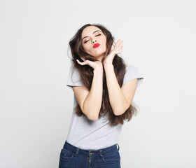 charming smiling young woman with long fark hair dressed in a white t-shirt and jeans