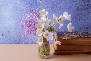 Lilac and anemones flower bouquet in a jar and vinage books. Spring, Mother's Day or March 8 still life composition