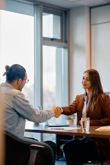 Young businesswoman greets her male colleague in office.