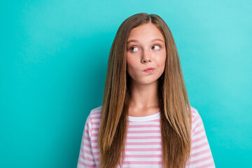 Portrait of minded pensive girl look interested empty space hesitate isolated on turquoise color...