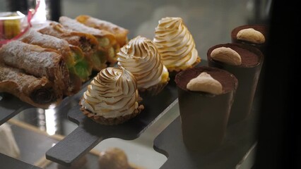 Various cakes on the counter in a modern cafe or pastry shop. Delicious fresh cakes in the pastry shop behind the glass.
