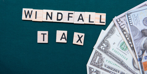 inscription windfall tax next to US dollars. Concept of windfall tax 
