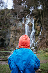 Ein Junge betrachtet einen Wasserfall