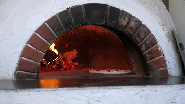 Traditional Italian pizza is baked in a stone wood-burning oven in a modern pizzeria. Pizza concept.