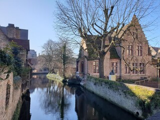 Fototapeta premium Classic panoramic view of the historic city center of Bruges (Brugge), West Flanders province, Belgium. Cityscape of Bruges with canal. Brugge streets and historic centre of medieval historic city.