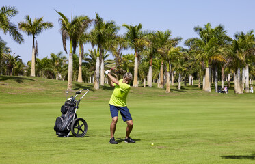Obraz premium Golfer on a golf course, ready to tee off. Golfer with golf club hitting the ball for the perfect shot.
