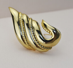 Old vintage brooch on beige background, accent retro jewelry for women
