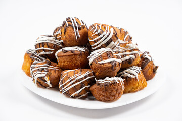 Small cupcakes with cocoa and white and milk chocolate with cream on a white background close-up