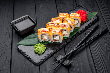 Traditional delicious fresh sushi roll set on a black background . Sushi roll with rice, cream cheese, salmon.