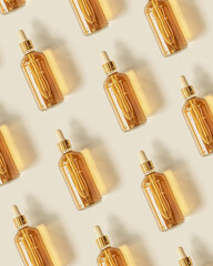 Trend Pattern from Serum or liquid collagen dropper bottle on beige background with sunlight. Anti age cosmetics products. Skincare beauty product, summer concept. Above view