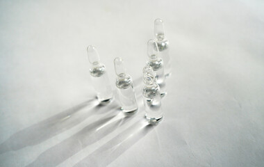 Transparent ampoules with clear liquid on a white background
