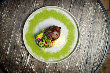 Cut of meat with boiled vegetables and mashed potatoes.