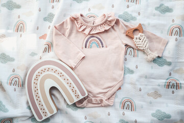 Pink baby bodysuit on a muslin swaddle