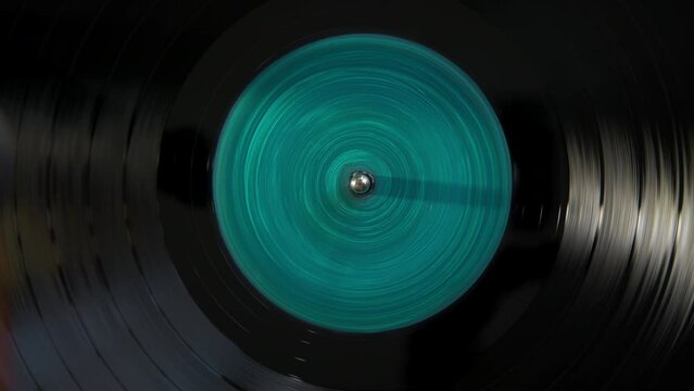 Black vinyl Retro with turquoise color screen in center record on DJ turntable. 