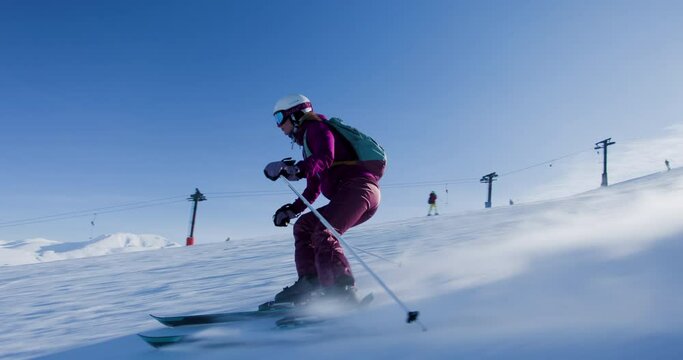 Girl skier skiing on slopes in a mountain winter ski resort. Slow motion video 50fps recorded with cinema camera.