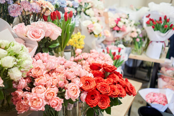 Flower shop concept. Different varieties fresh spring flowers in refrigerator room for flowers. Bouquets on shelf, florist business