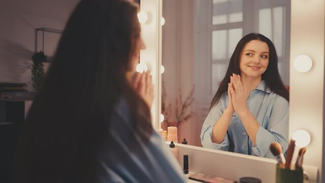 Young woman looking in mirror, evening beauty routine, getting ready for a date