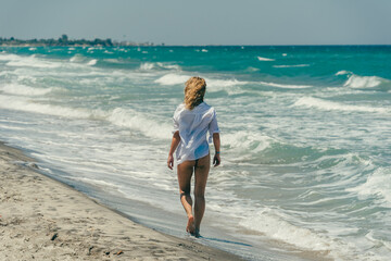 Kobieta spacerująca na plaży w Mastichari, Wyspa Kos - obrazy, fototapety, plakaty