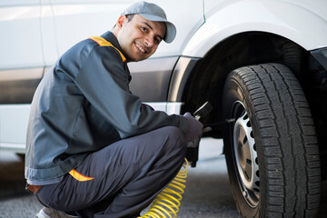Fototapeta na wymiar Mechanic checking the pressure of a van tire