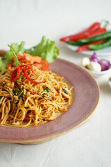mie tek tek or  javanese fried noodle made with egg noodles with chicken, cabbage, meatballs, scrambled eggs. indonesian food
