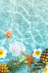 Obraz na płótnie Canvas Yellow pineapple, seashells and flowers on a blue water background.