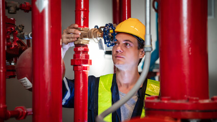 A team of engineers is examining the plumbing and water valves inside an industrial facility. - obrazy, fototapety, plakaty