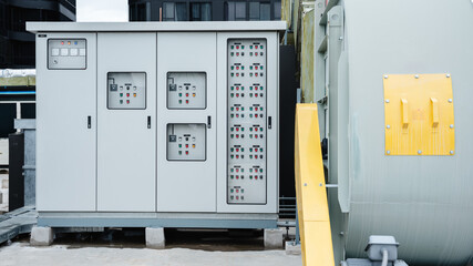 The electrical room of a commercial building contains multiple smart meters, a main power breaker, and various meter stacks and cabinets.