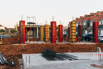 Construction site with steel formworks and reinforcing bars for pillars ready for concrete pouring