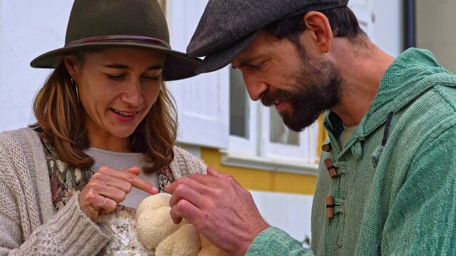 happy young couple of farmers holding production blocks of lion mane mushrooms outdoors against the house. European small business