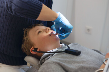 Kid in a dental clinic. Orthodontic treatment. Children's dentistry, Pediatric Dentistry. boy in braces on his teeth at a dentist's appointment. Oral health and hygiene.