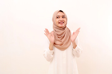 Happy young asian muslim woman with excited face expression while looking sideways at blank space