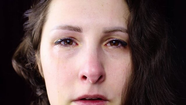 Upset and depressed Caucasian brunette woman crying face with tears close up