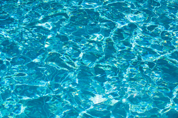 Ripple Water in swimming pool with sun reflection. Wavy water background.