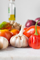 Garlic bulbs and tomatoes on a marble tray, raw garlic and tomatoes for making pasta and pizza sauce, Allium sativum and Solanum lycopersicum	