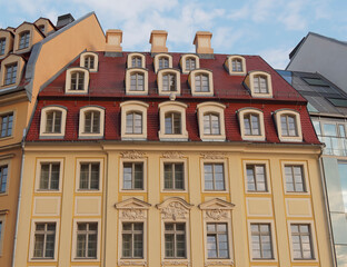 Fototapeta na wymiar An impressive vintage house facade with windows as a geometric pattern and ceramic tiles roof, fully restored. Travel to Dresden, Saxony Germany.