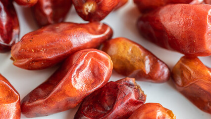 Close up of dried up pequin peppers on white background.