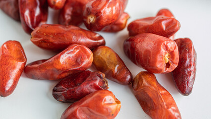 Close up of dried up pequin peppers on white background.