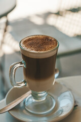 A cup of cappuccino coffee on a table in a cafe. Coffee hot drink in a ceramic cup for breakfast in the morning.