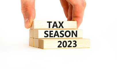 Tax season 2023 symbol. Concept words Tax season 2023 on wooden blocks on a beautiful white table white background. Businessman hand. Business Tax season 2023 concept. Copy space.