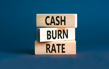 Cash burn rate symbol. Concept words Cash burn rate on wooden blocks on a beautiful grey table grey background. Business cash burn rate concept. Copy space.