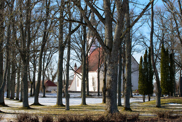 beautiful white church with red roof in outdoor park in sunny spring day