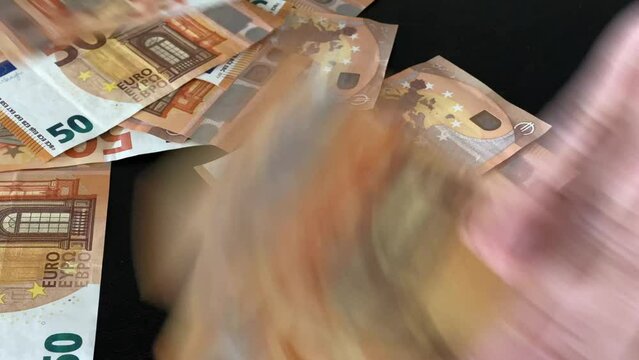 Hands hurl money on the table. 50 euro money banknotes bill close up