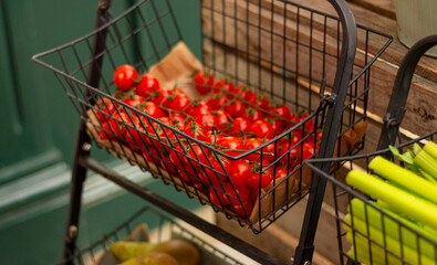 small red tomatoes in basket on the counter of vegetable market
