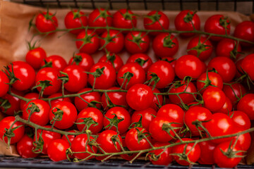 small red tomatoes on the counter of vegetable market, background